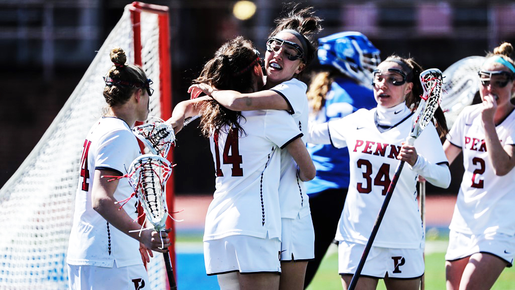 Penn women's lacrosse players celebrate near the goal.