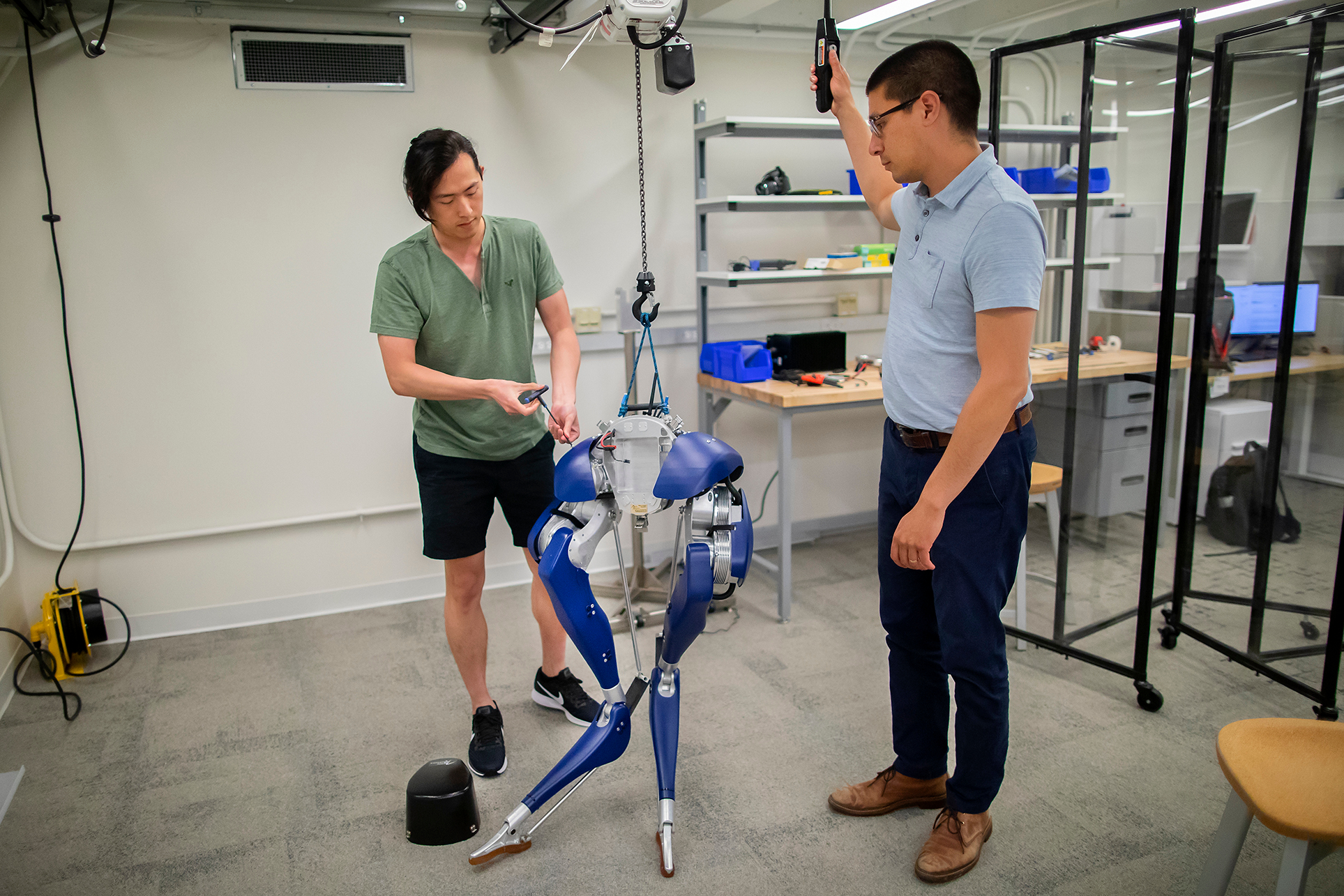 two people working on a set of robotic legs
