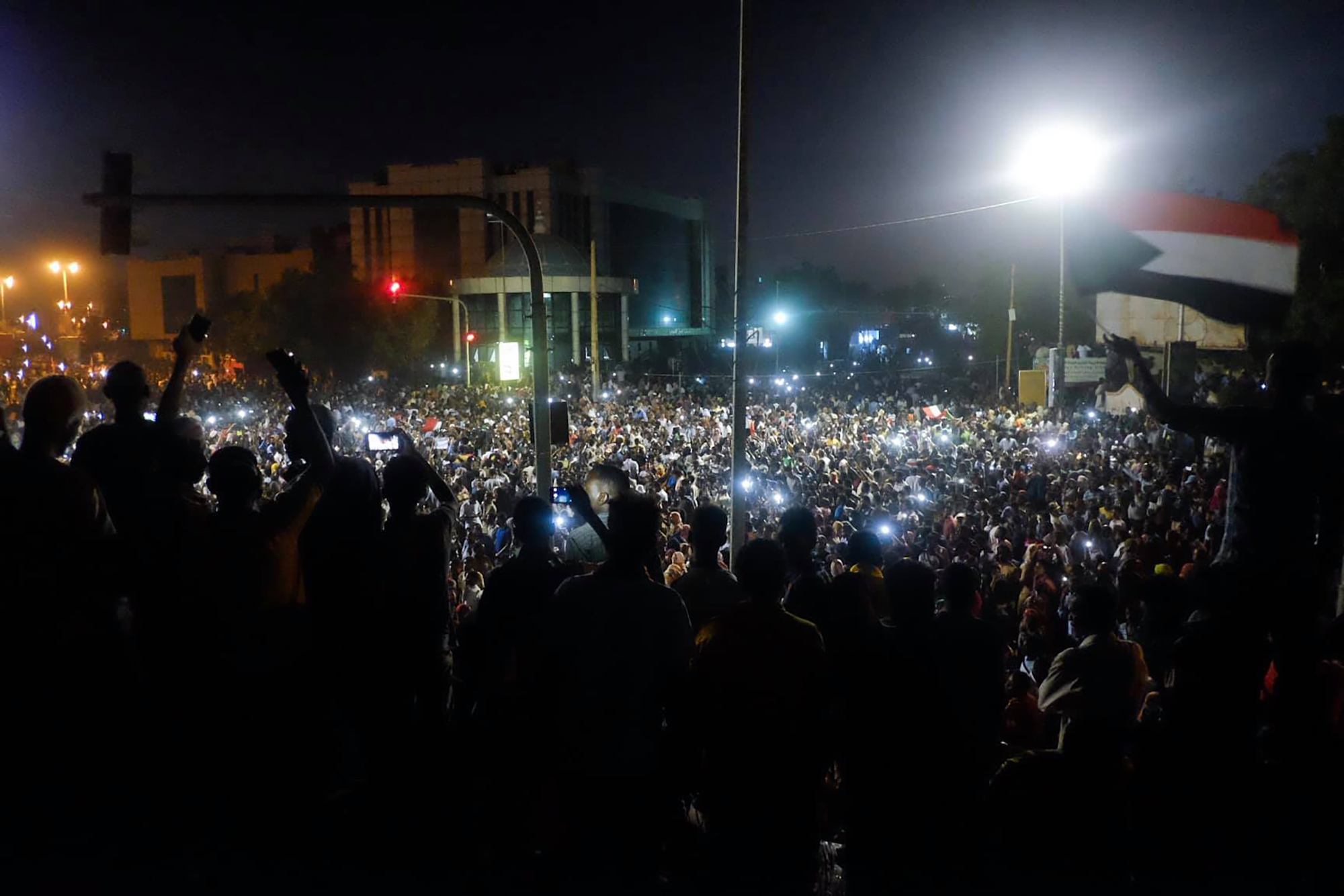 Protestors chant and rally at night in front of the the Sudanese Army headquarters in Khartoum.