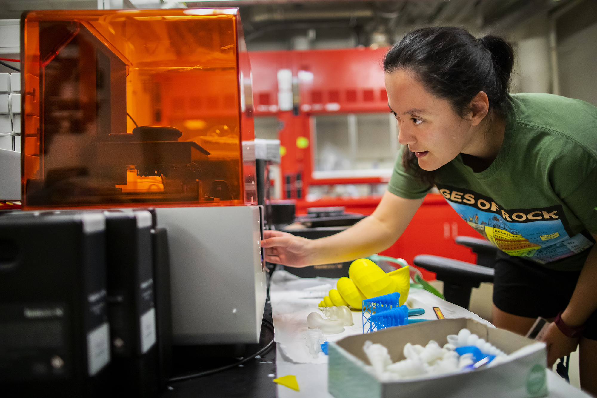 Scientist looks at a 3D printer in a scientific lab