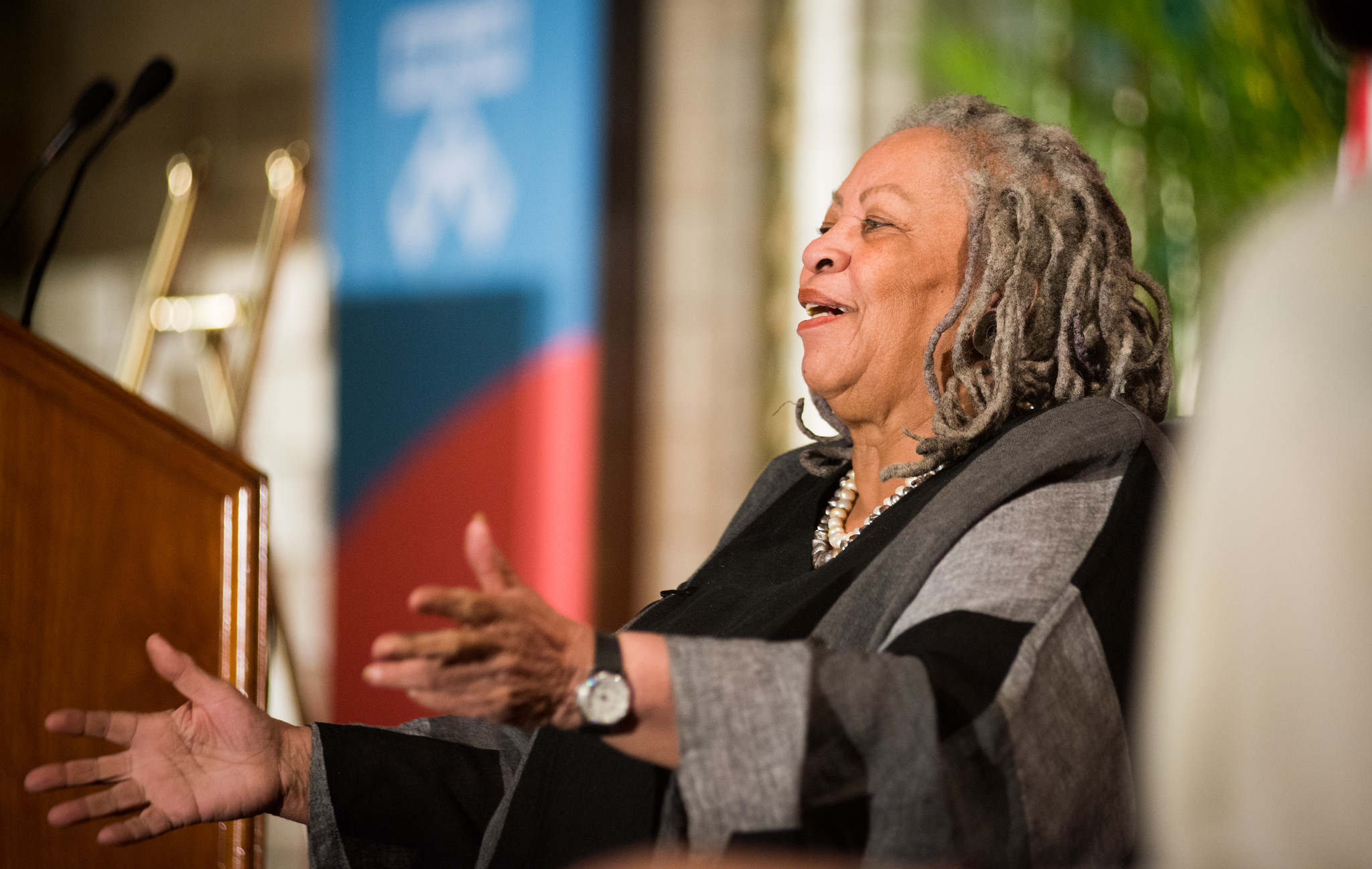 Toni Morrison reaches out her arms on stage