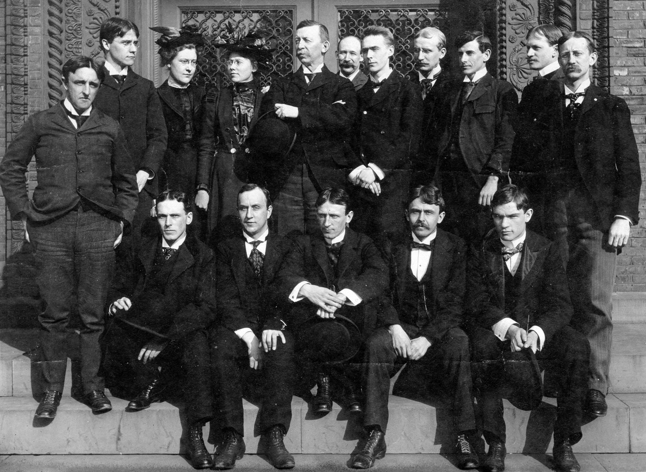 smith posing on a staircase outside with a large group of students