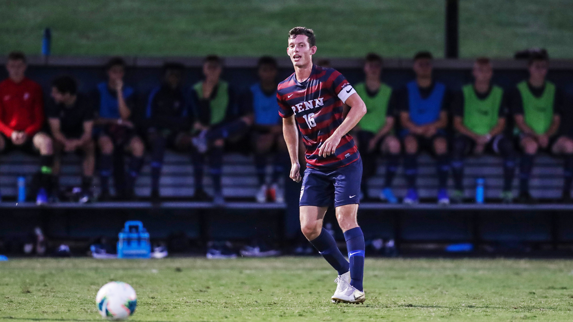 Alex Touche of the men's soccer team dribbles the ball down the field.