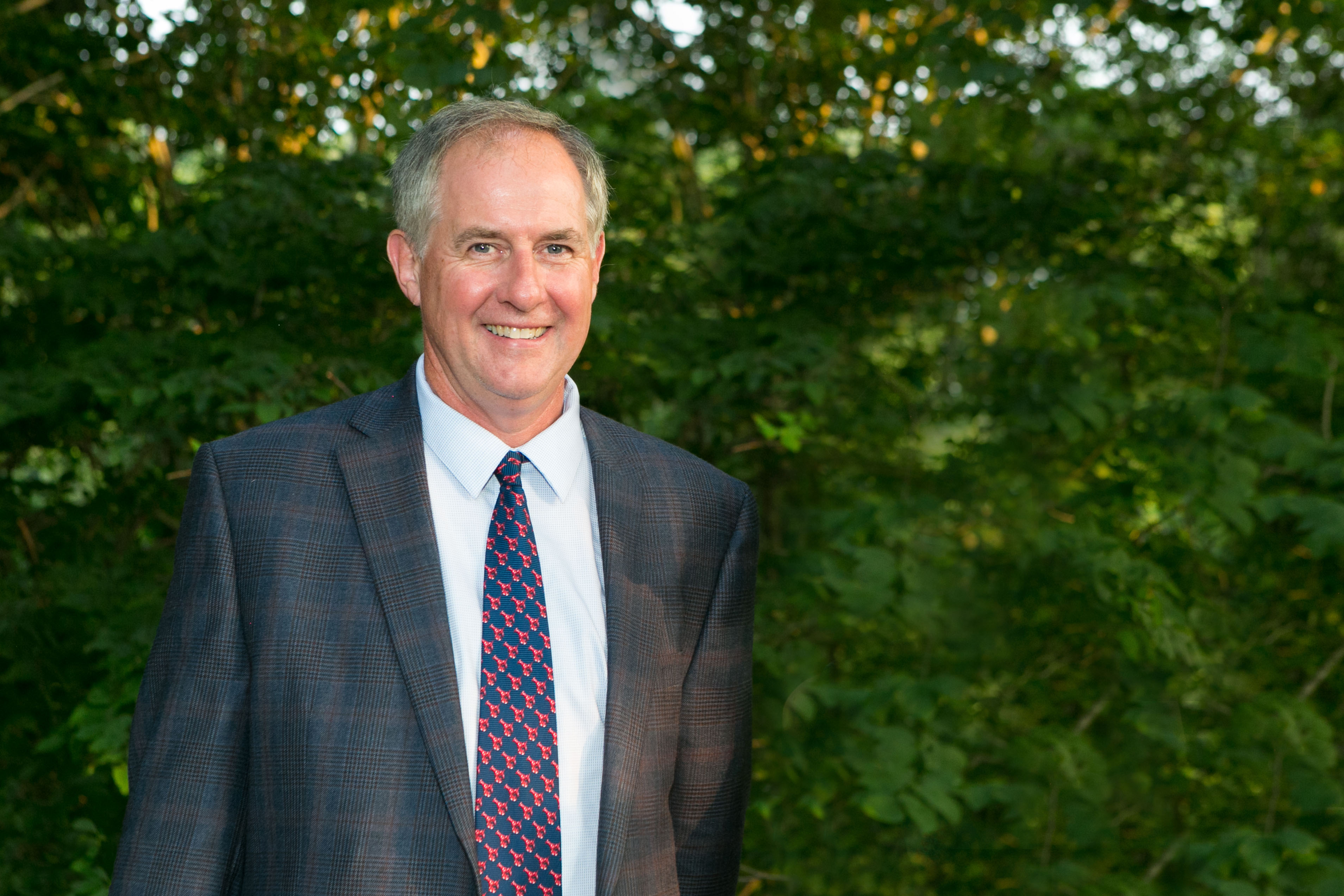 Bill Cullina smiles in front of trees