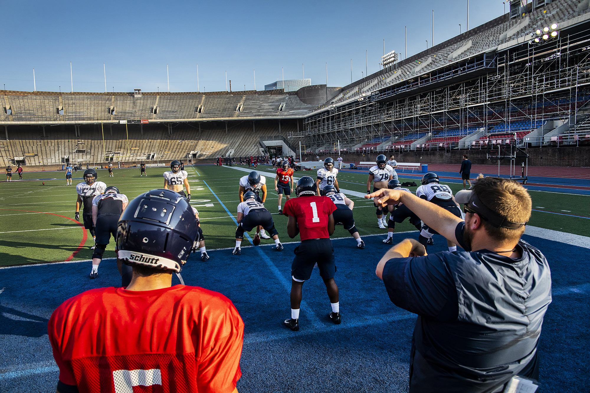 From the end zone, Penn football players practice a play from their own goal line.