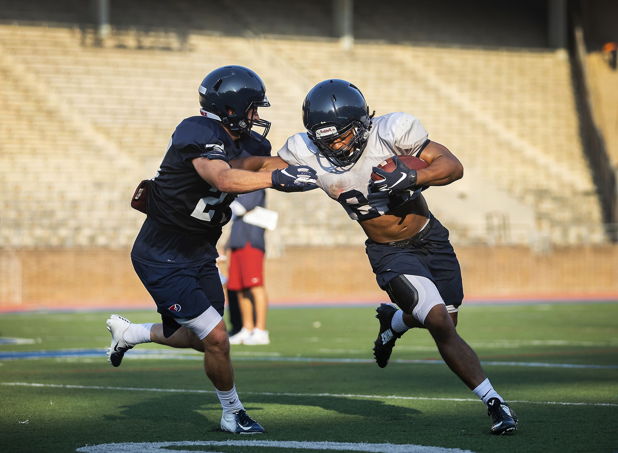 A defender attempts to tackle a running back during Penn football preseason practice at Franklin Field.