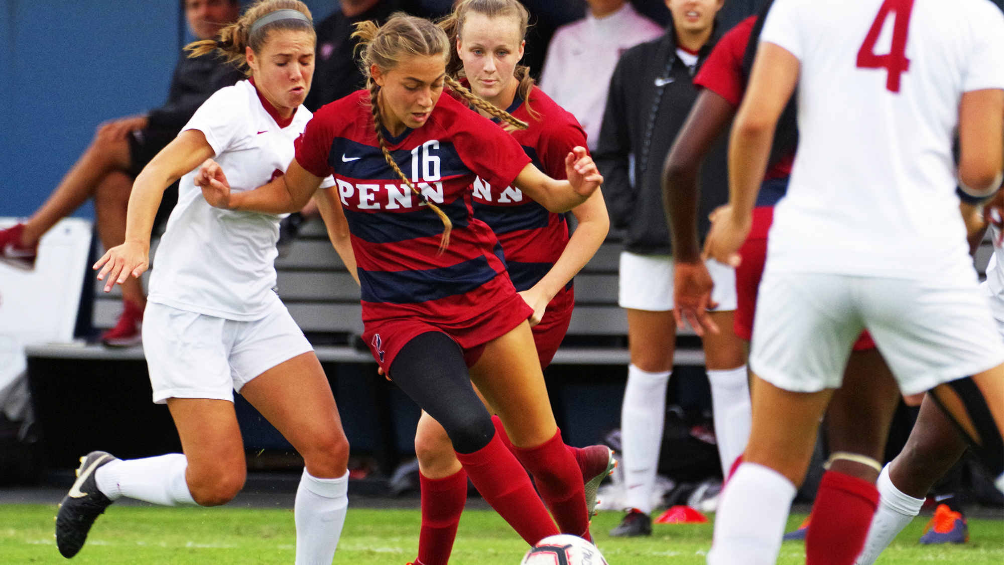 Breukelen Woodard of the women's soccer team drives the ball between two defenders.