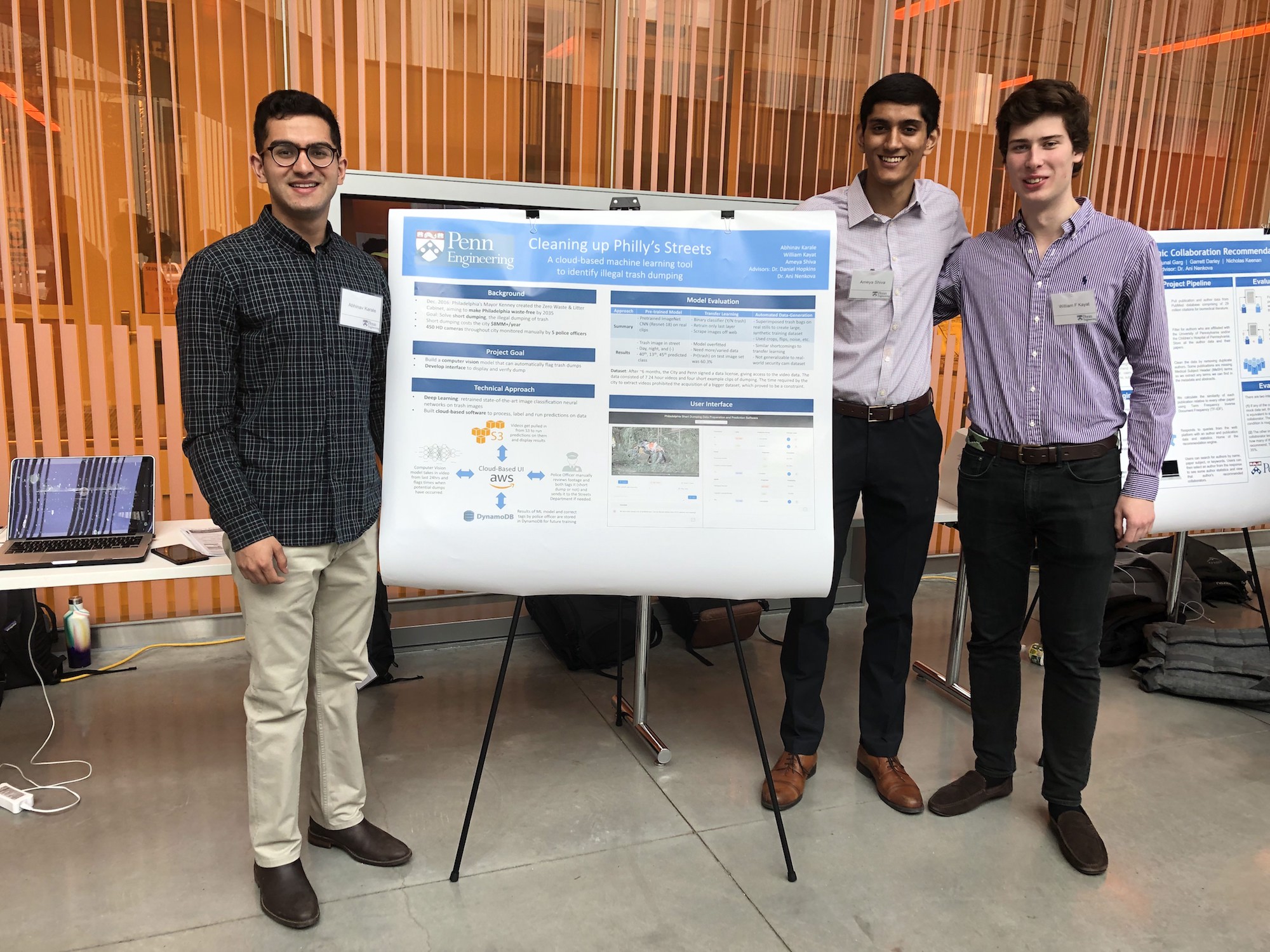 Three students stand next to a poster entitled "Cleaning Up Philly's Streets" which describes their project