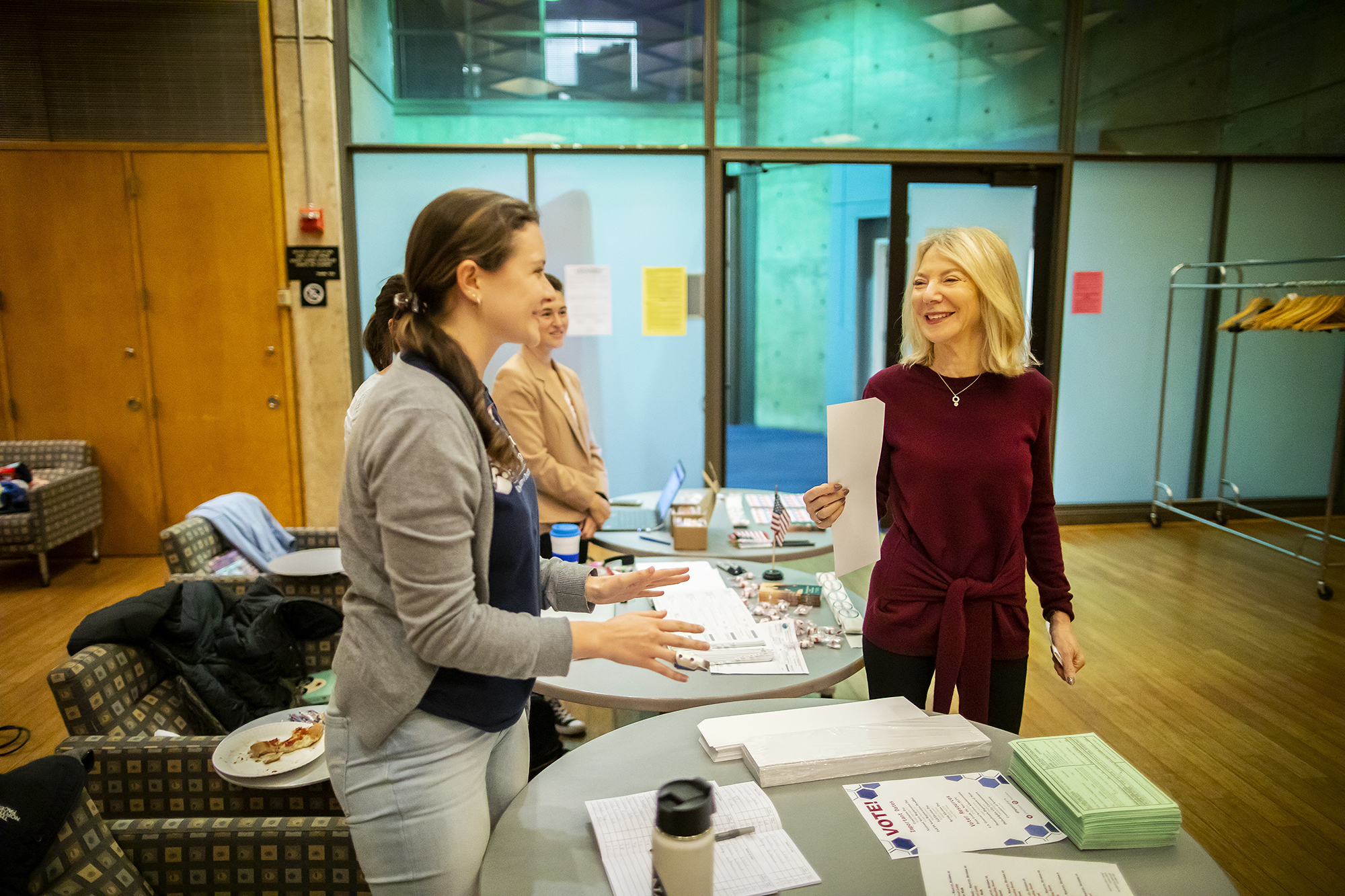 Penn President Amy Gutmann receives her paper ballot for use in the voting machine from a poll worker at Vance Hall.
