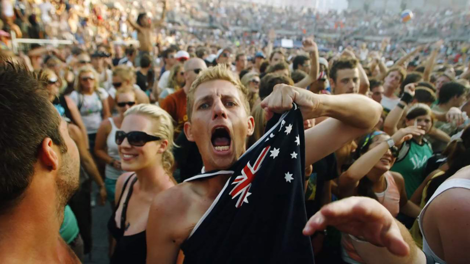 Australian person angrily shouts while gripping flag shirt