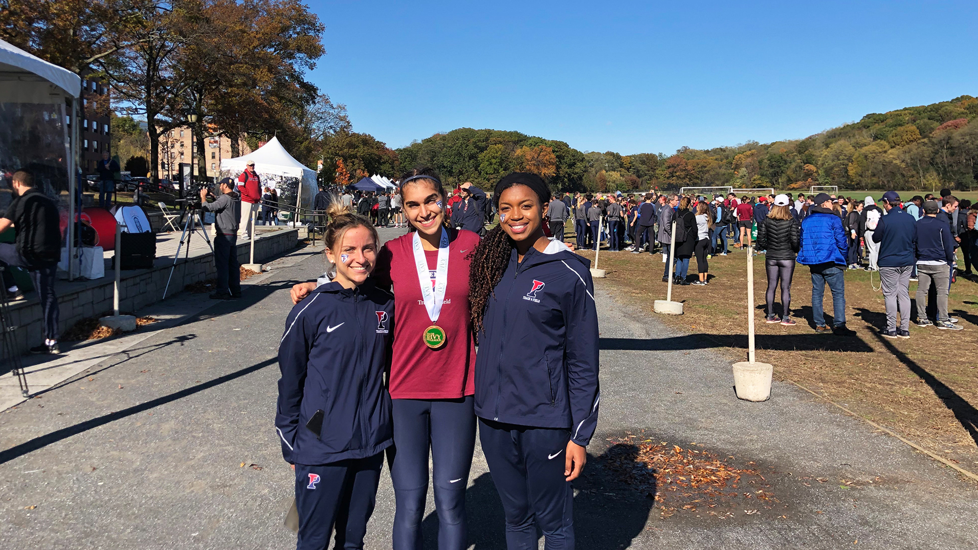 From left, Ariana Gardizy, Maddie Villalba, and Nia Akins of the women’s cross country team stand together at the Ivy Heps in the Bronx.  