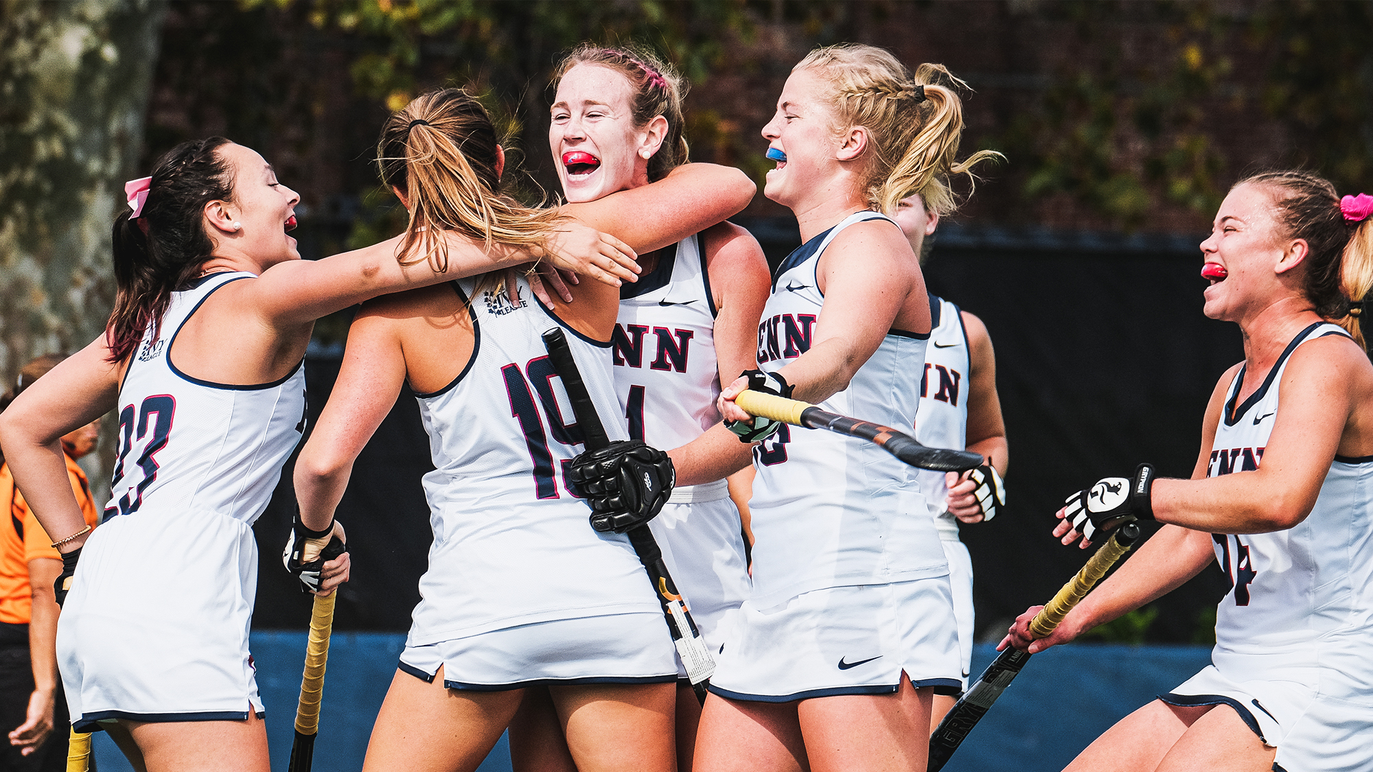 Members of the field hockey team celebrate and hug against Brown.