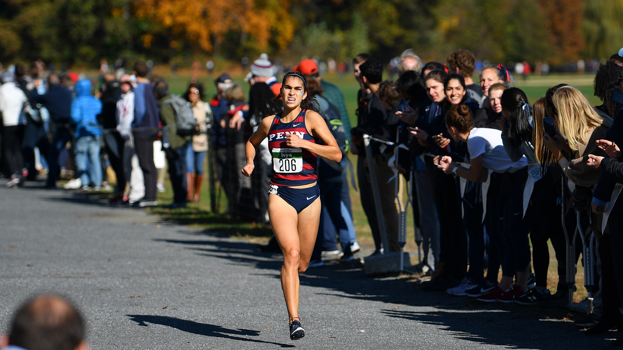 Senior Maddie Villalba of the women's cross country team runs on the pavement during a race.