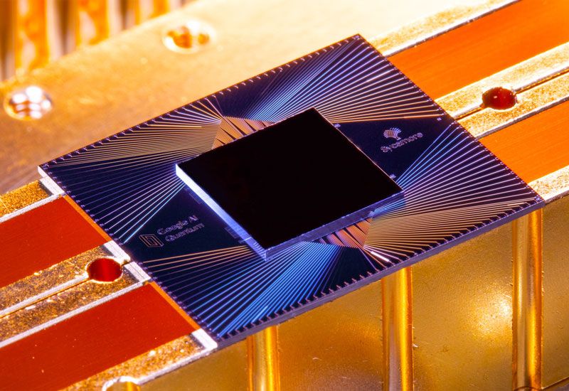 a computer chip with sycamore written on one side, on the top is a pattern of lines that form triangles and the chip is resting on a metal background with orange lighting