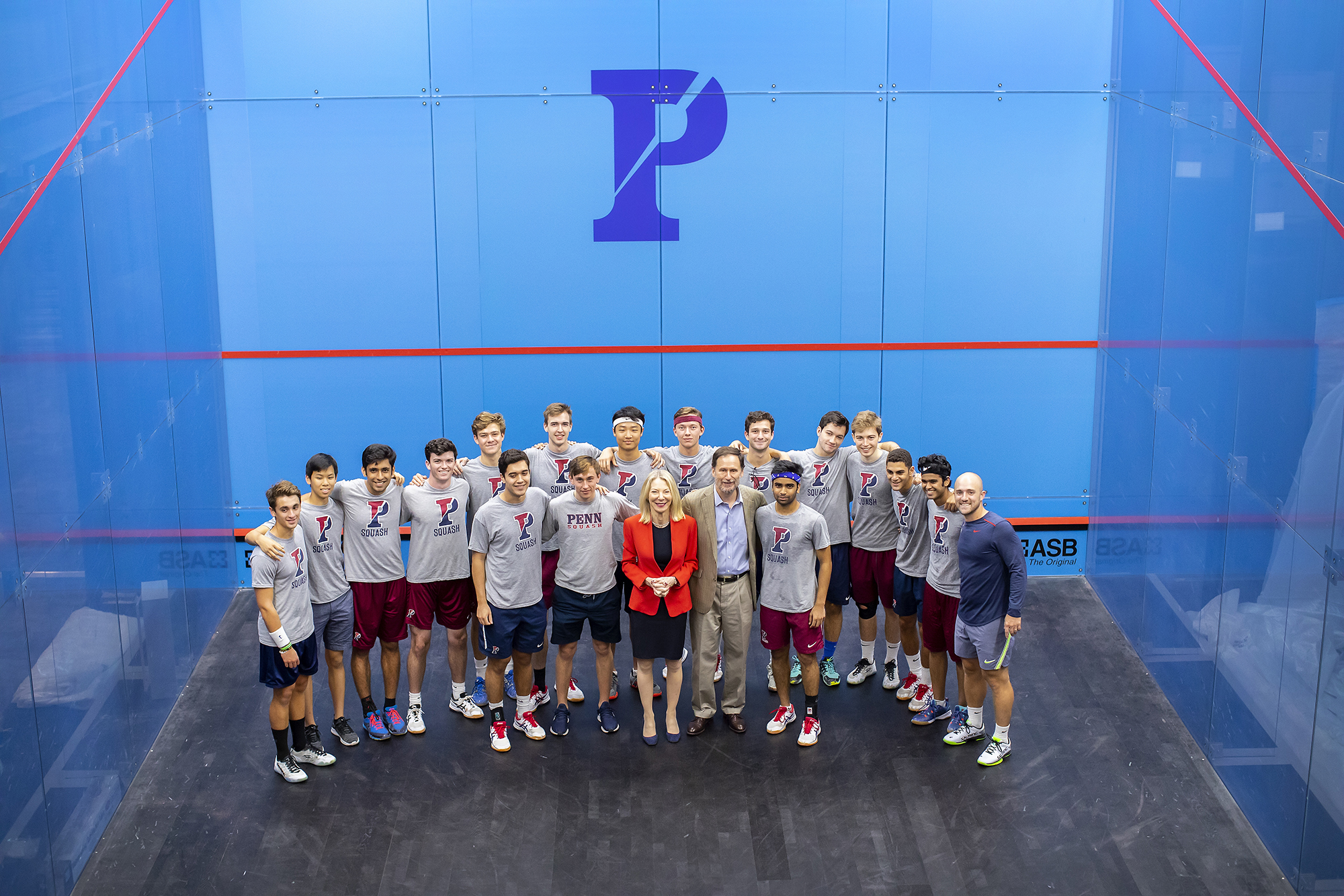 President Gutmann and her husband University Professor Michael Doyle of Columbia pose with members of the men's squash team in one of the new glass courts.