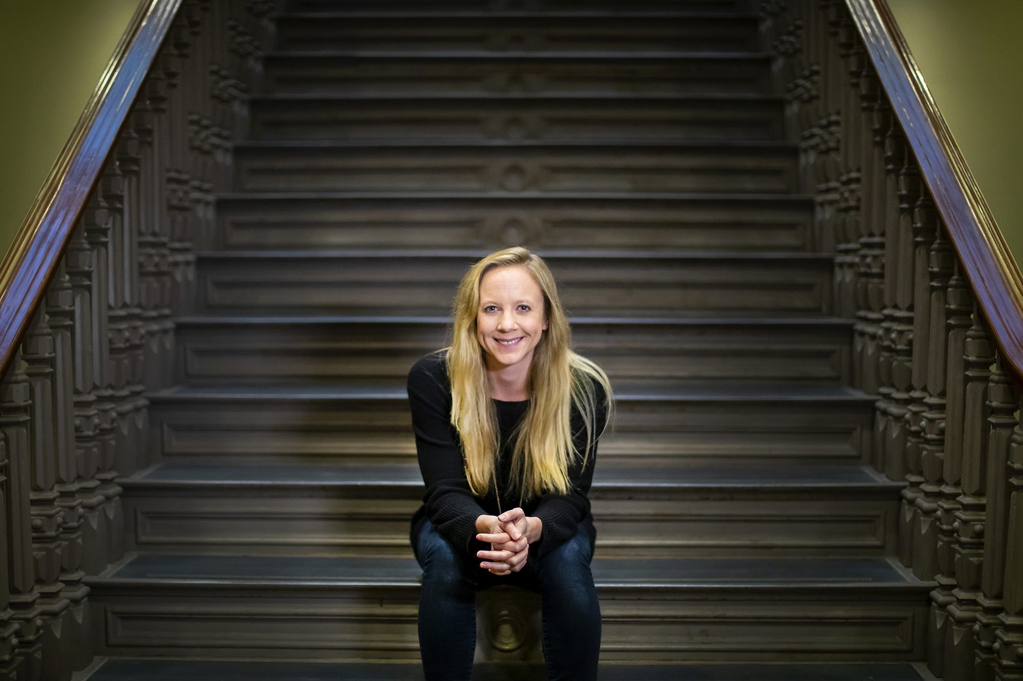 Person poses, sitting on a staircase