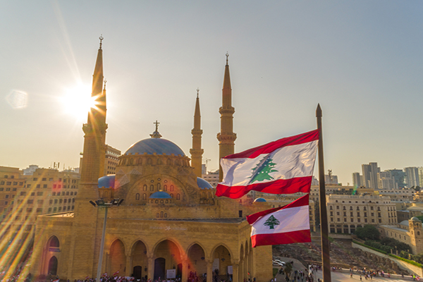 drone shot of Martyr square, showing the Lebanese flag in foreground along with Mohammad Al Amine Mosque and st. George Church in the background, during the Lebanese revolution
