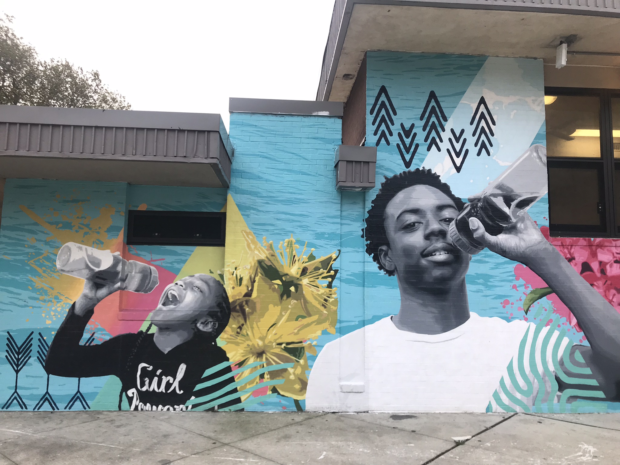 City mural depicts two young people enjoying drinking from reusable water bottles