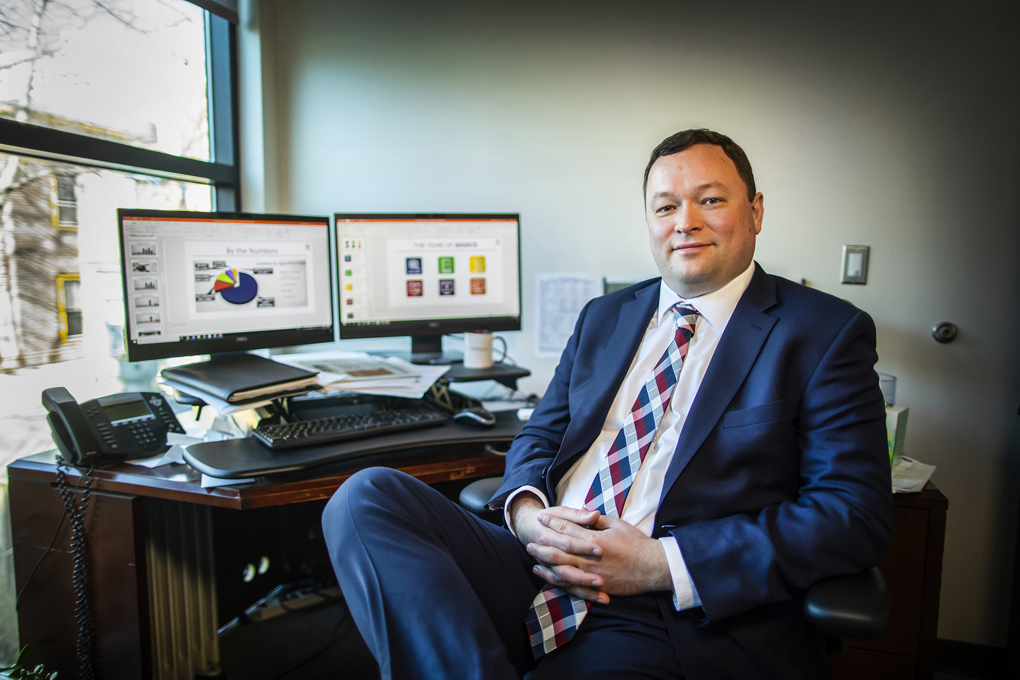 Nick Falcone seated at his desk in front of his dual-monitor computer