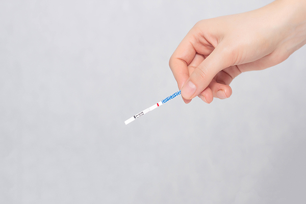 hand holding an at-home ovulation test strip