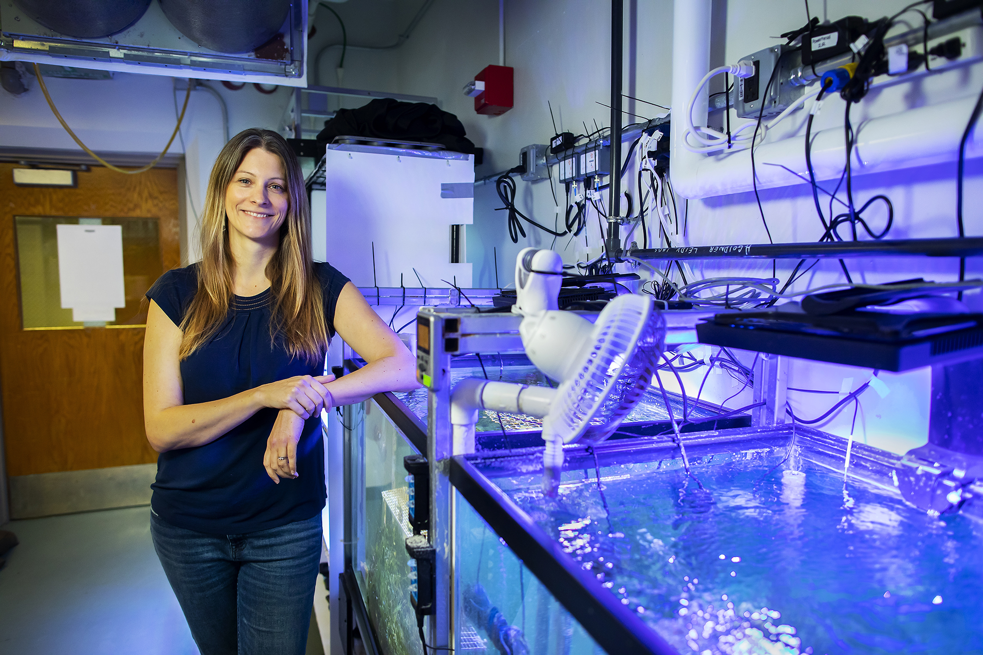 Marine biologist Katie Barott with tanks containing corals in her lab at Penn