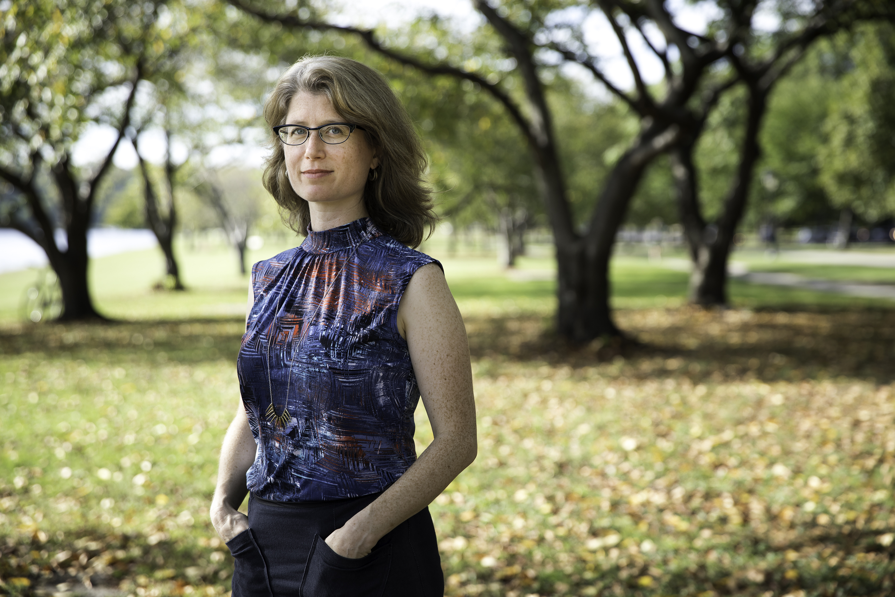 Author Julia Bloch standing in a grove of trees. 