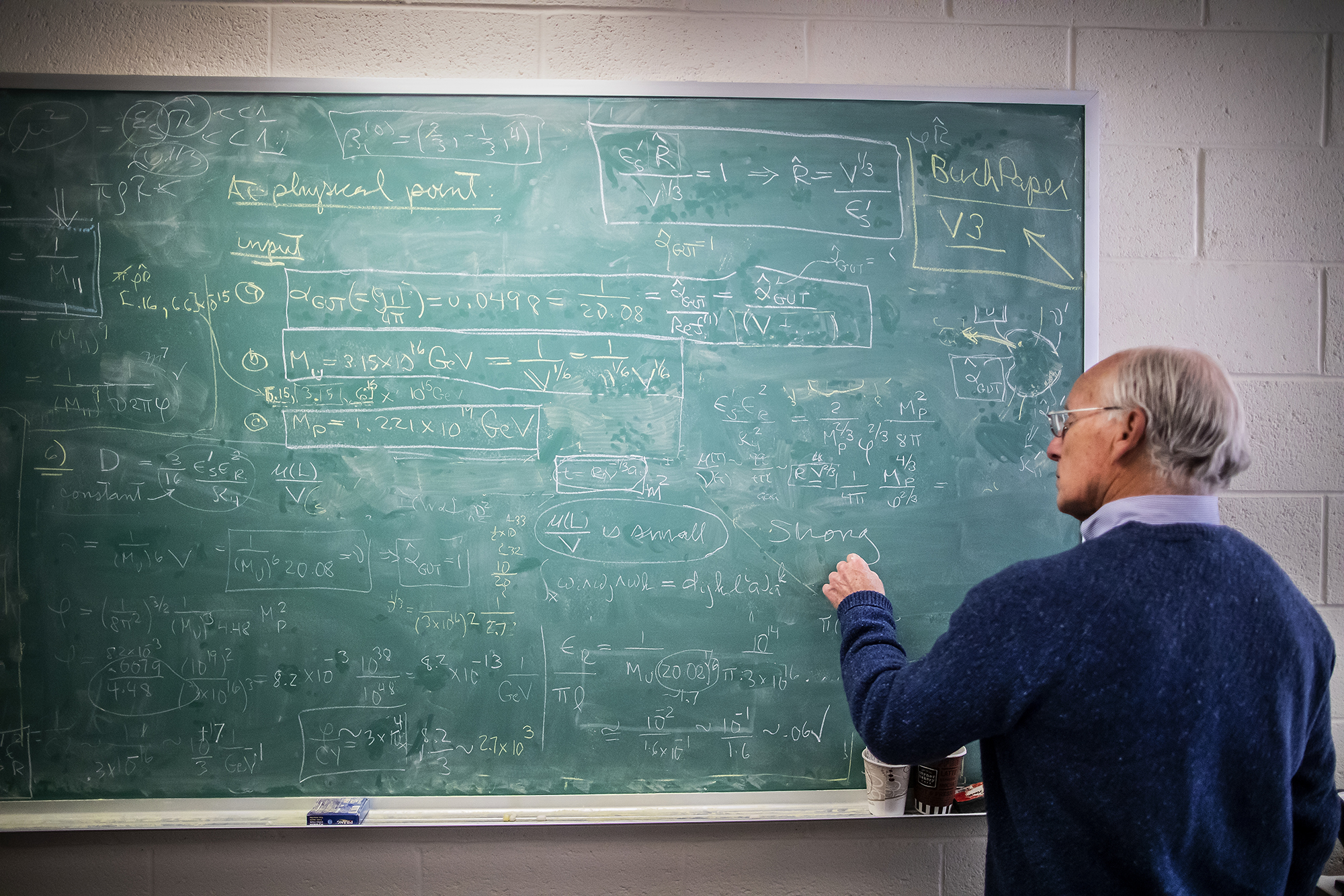 a person standing in front of a chalkboard covered in equations