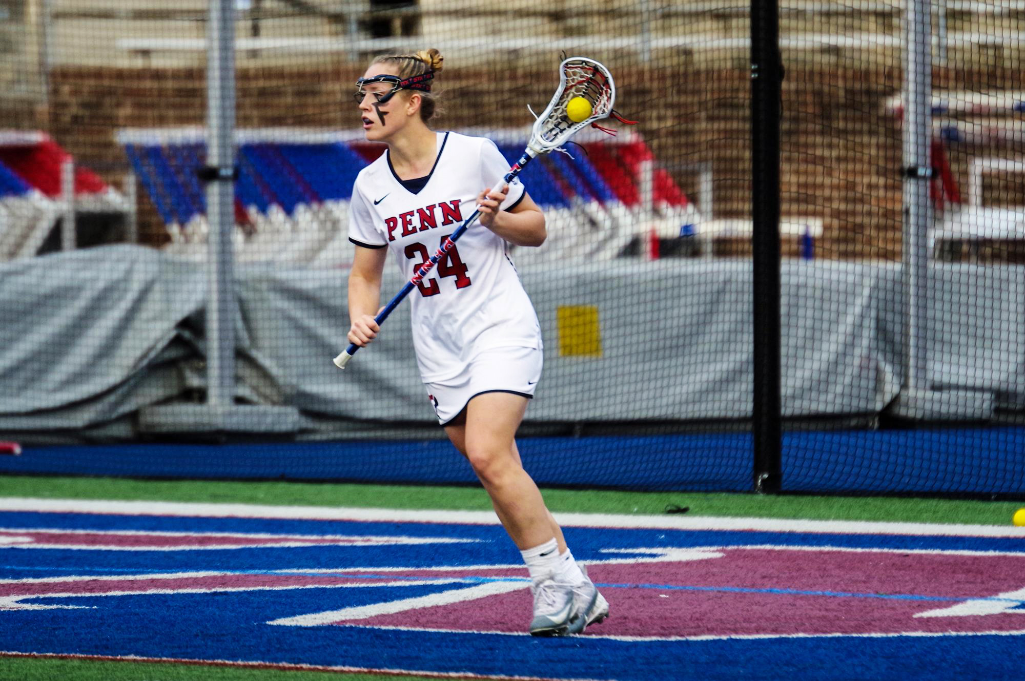 Gabby Rosenzweig of the women's lacrosse team holds her stick with a ball in it during a game.