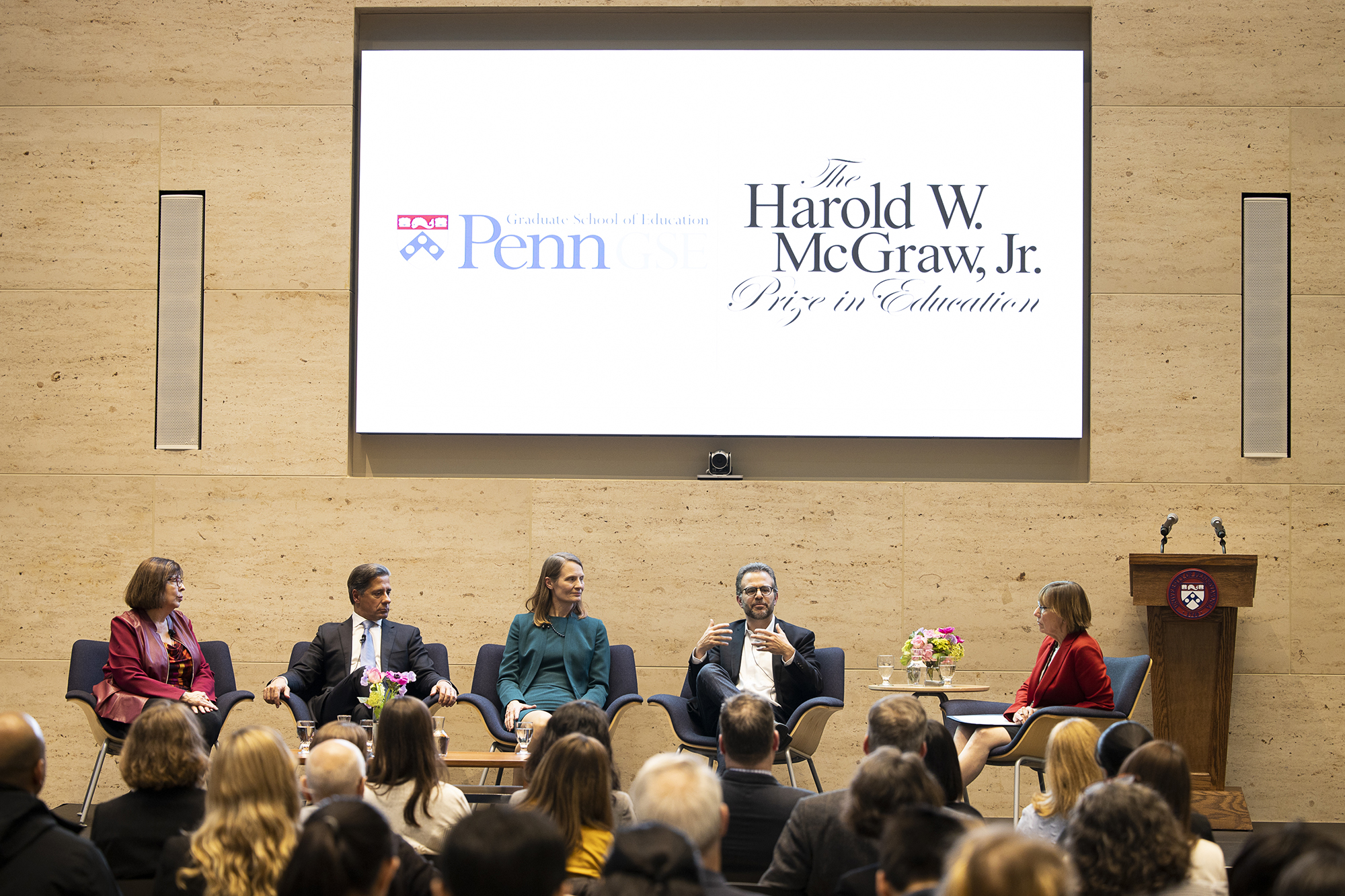 Five people sit on a stage in discussion with an audience in front, on projection on wall behind them reads The Harold W. McGraw, Jr. Prize in Education