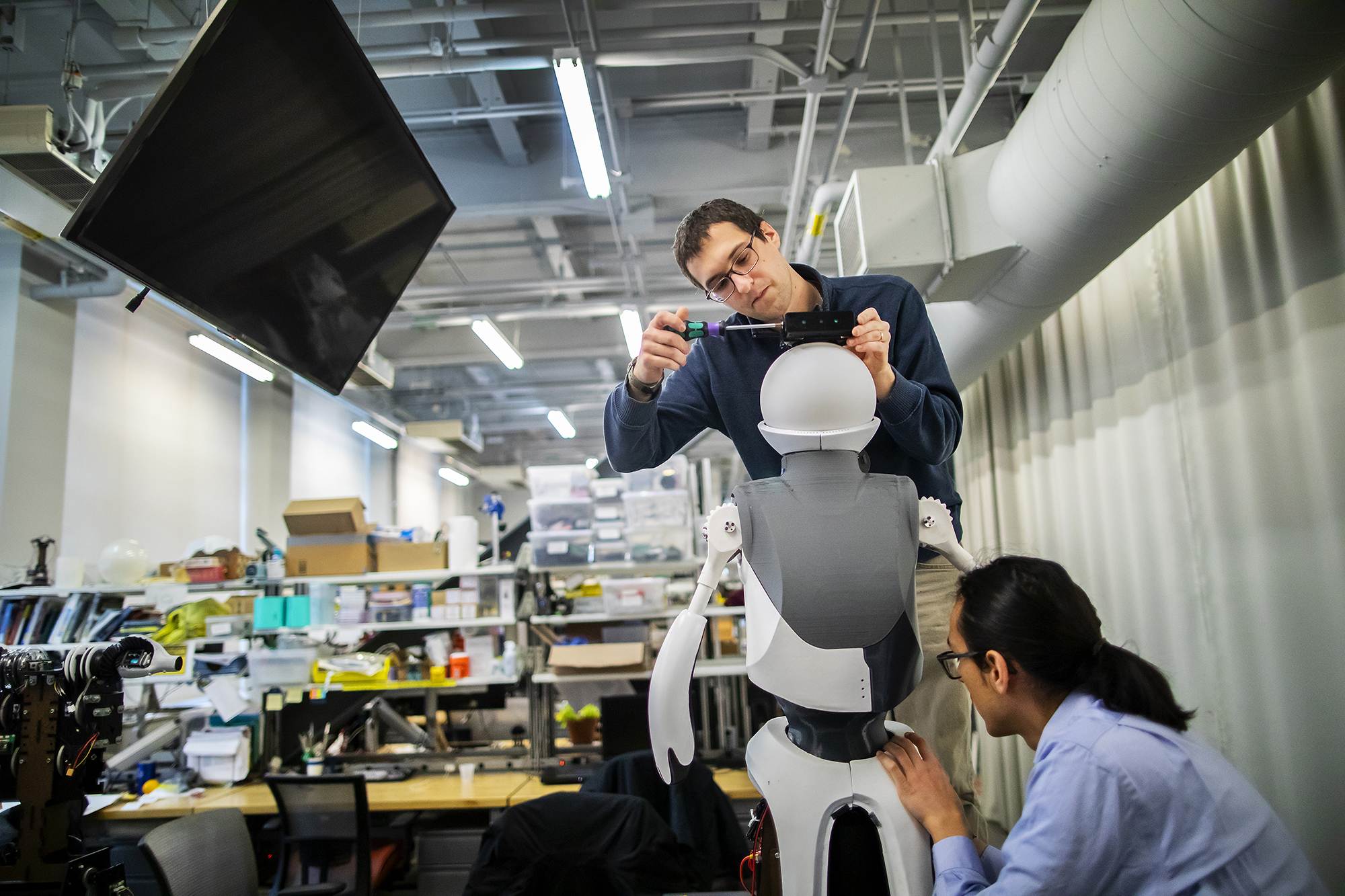Two people work on Quori the Robot at Pennovation Center.