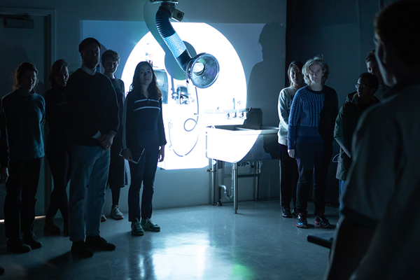 group in front of screen with light projected on it