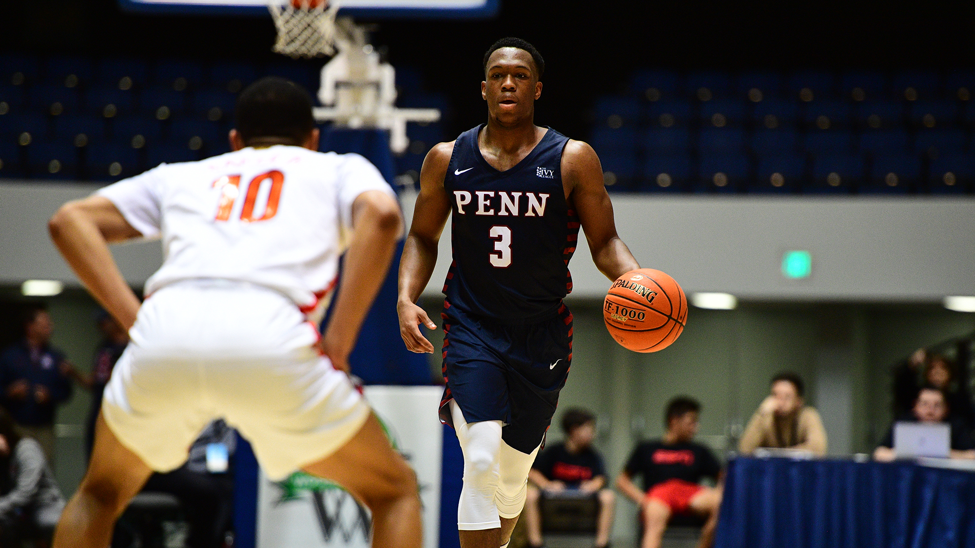 Jordan Dingle dribbles the basketball down the court during a Penn basketball game.