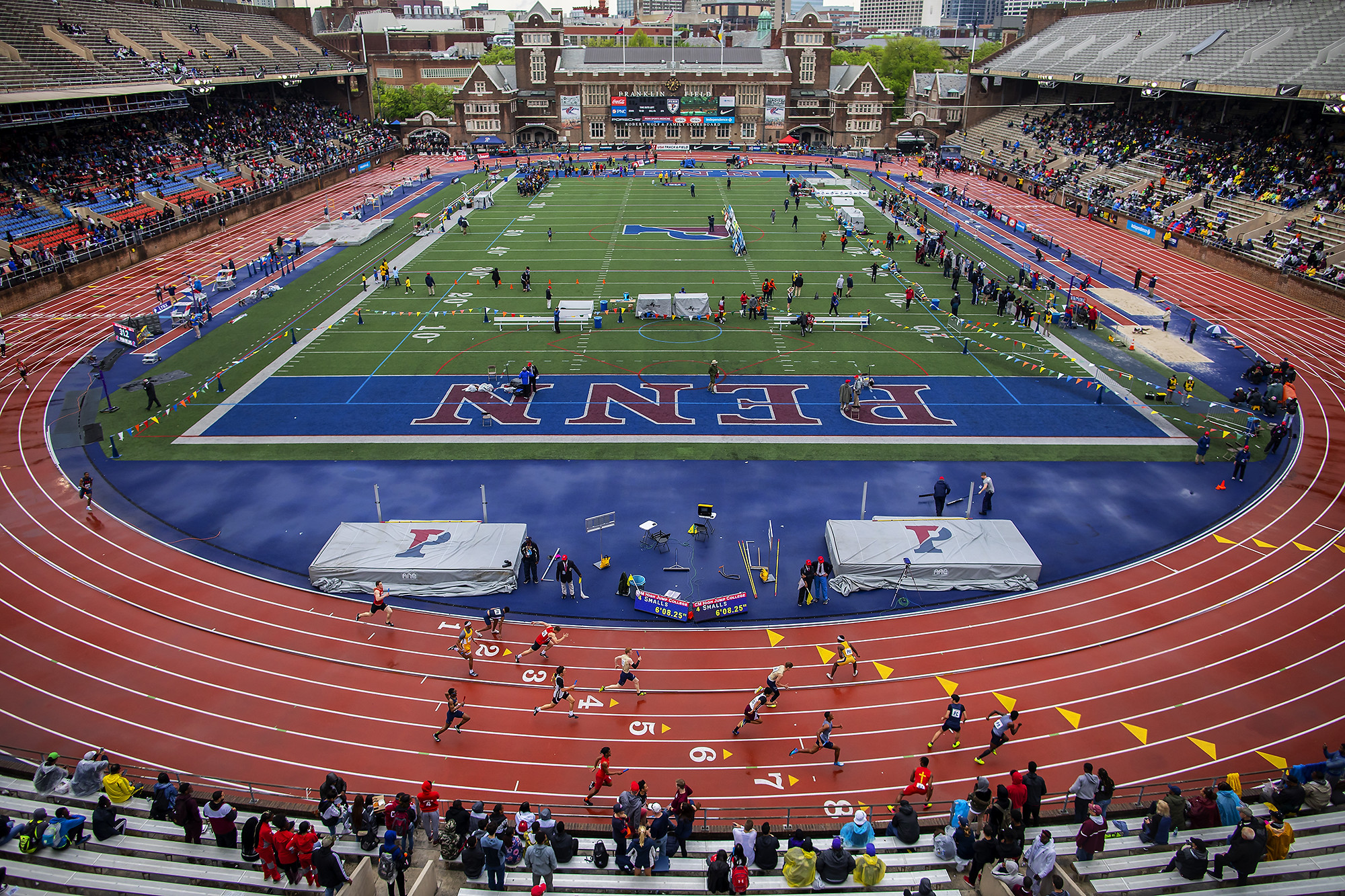 Runners race around the Franklin Field track at the 2019 Penn Relays.
