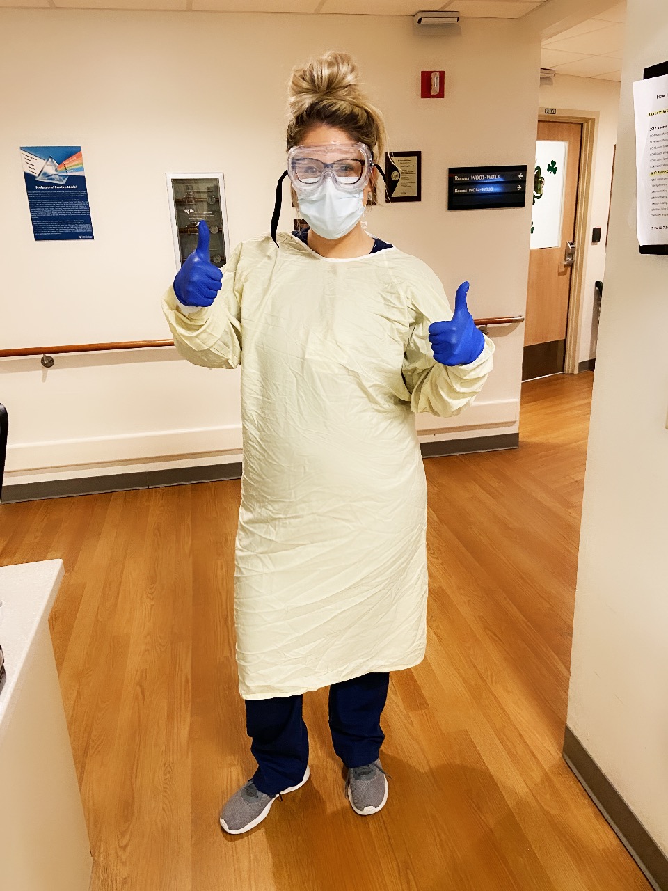 Person standing in a hospital wearing personal protective equipment. 