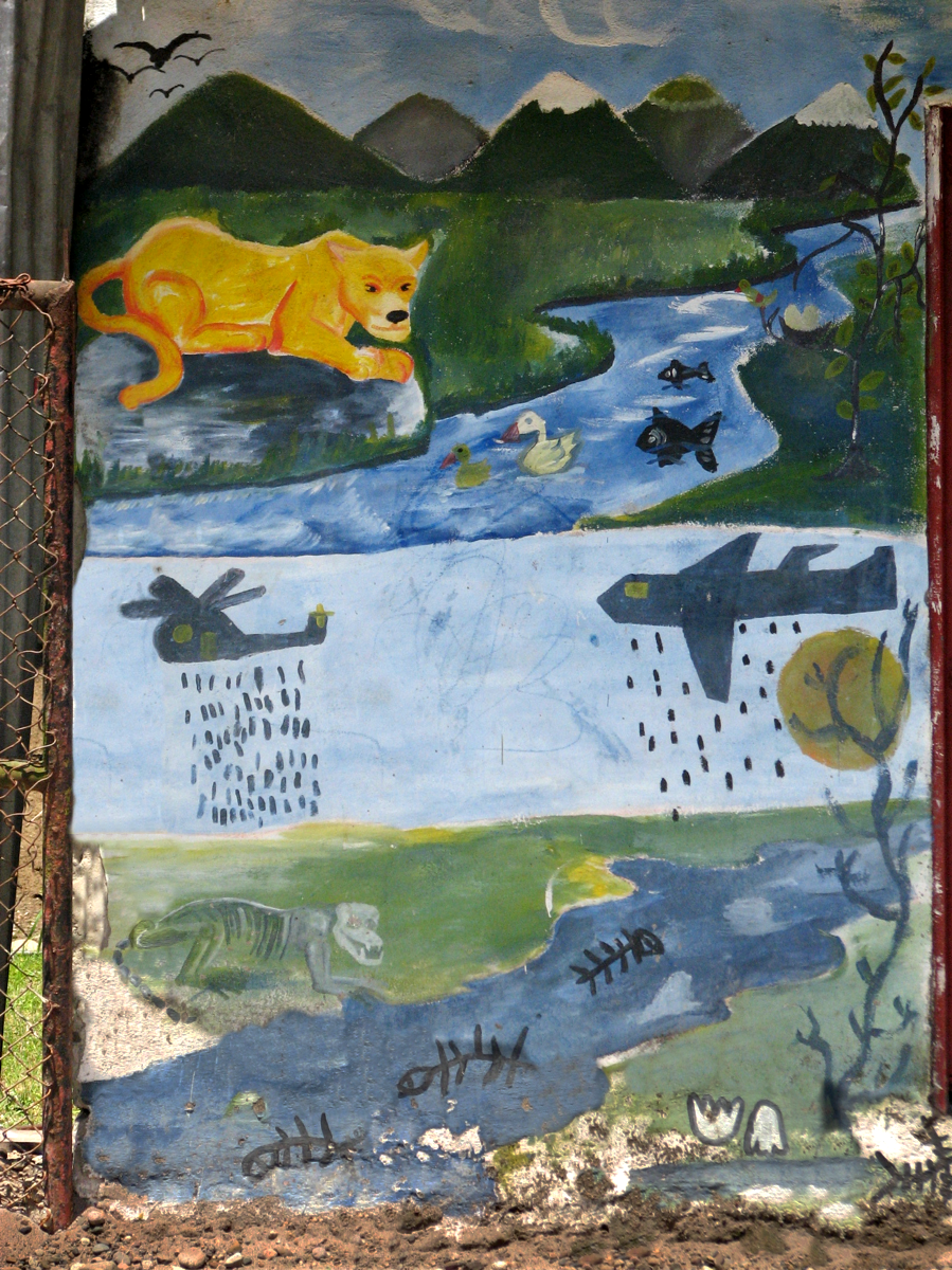 A diptych mural shows mountains and a flowing river with wildlife above; the same scene with skeletons below and a plane and helicopter raining chemicals