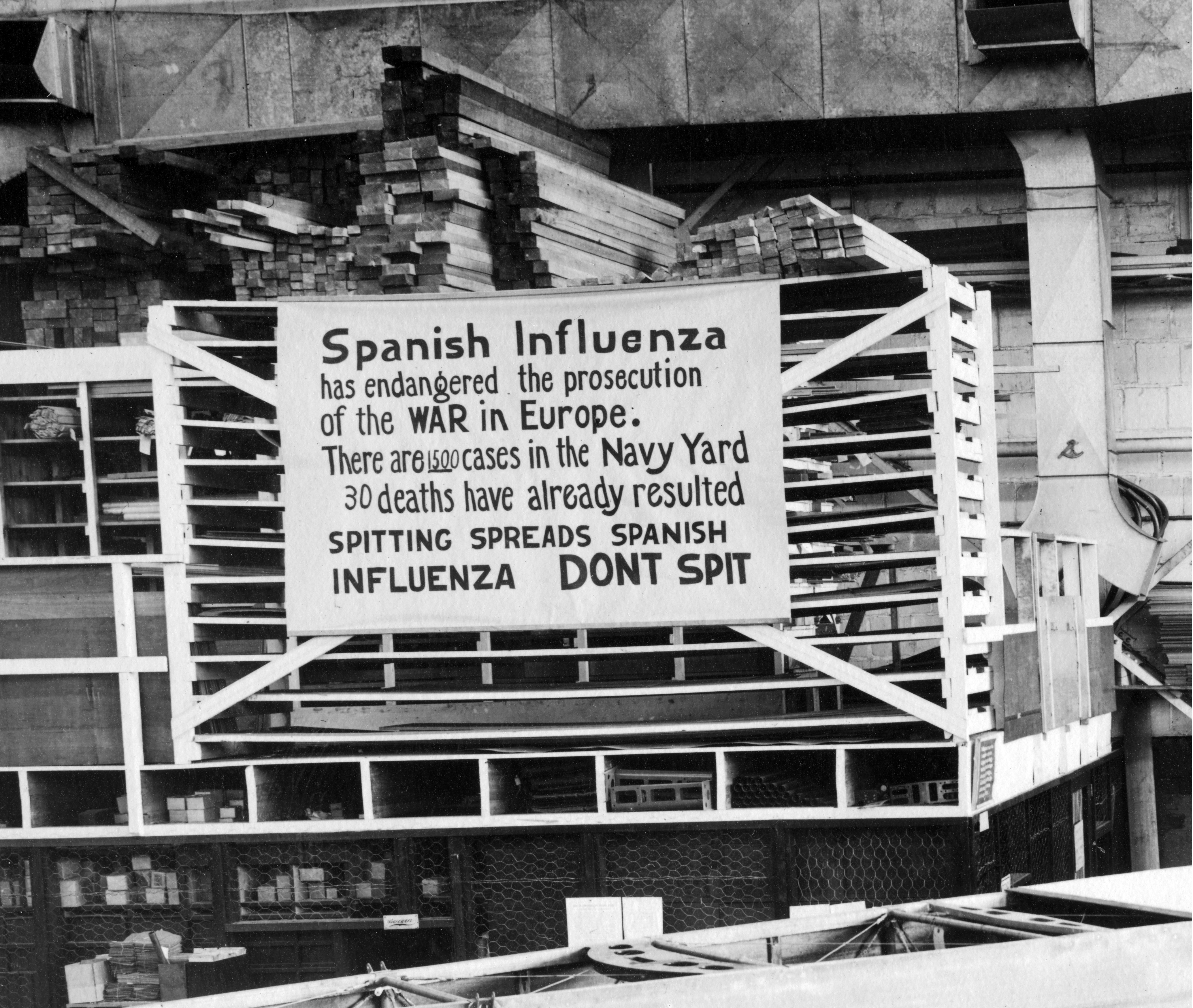 Sign reads: Spanish influenza has endangered the prosecution of the WAR in Europe. There are 1500 cases in the Navy Yard. 30 deaths have already resulted. Spitting spreads Spanish influenza don't spit
