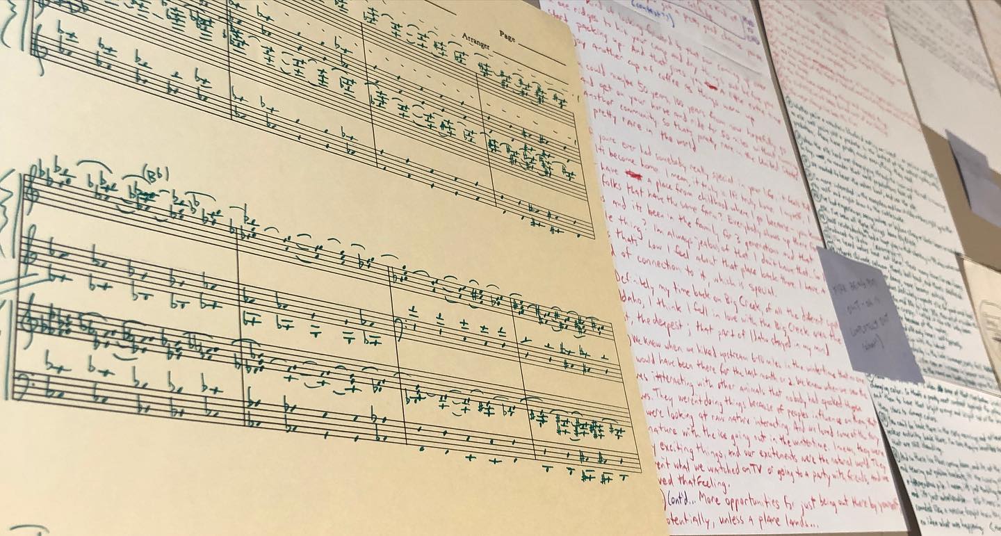 Sheet music laid atop a page of handwritten notes