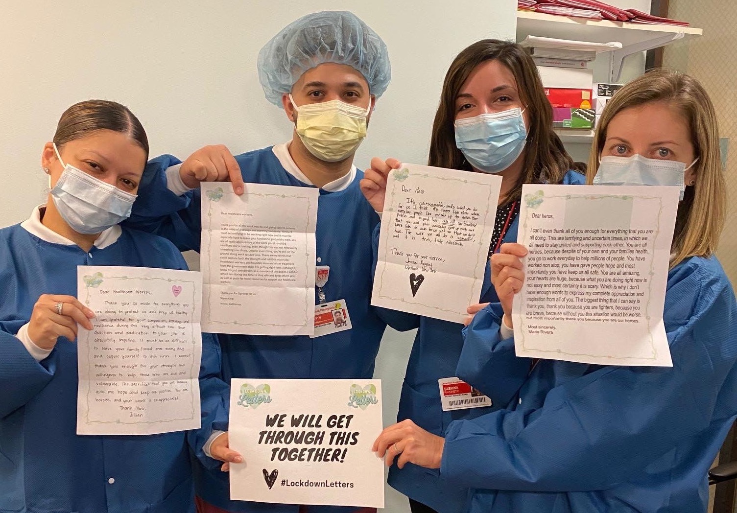 Group of health care workers holding up letters and a sign that says "We will get through this together! Lockdown Letters"