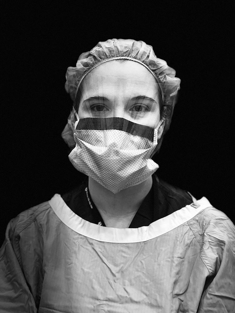 Black and white close-up image of a nurse wearing personal protective equipment.