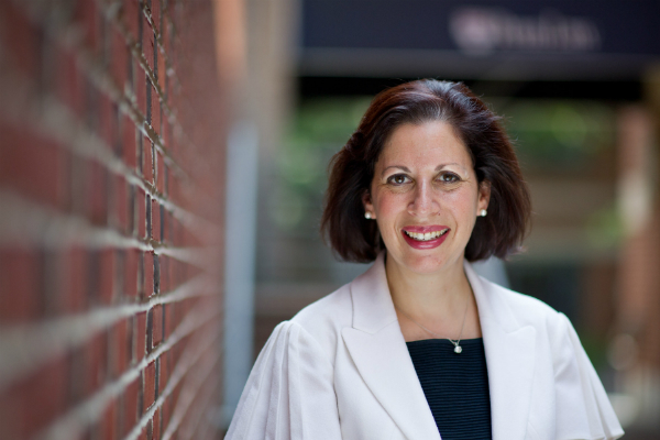 Claire Finkelstein smiles beside a brick building