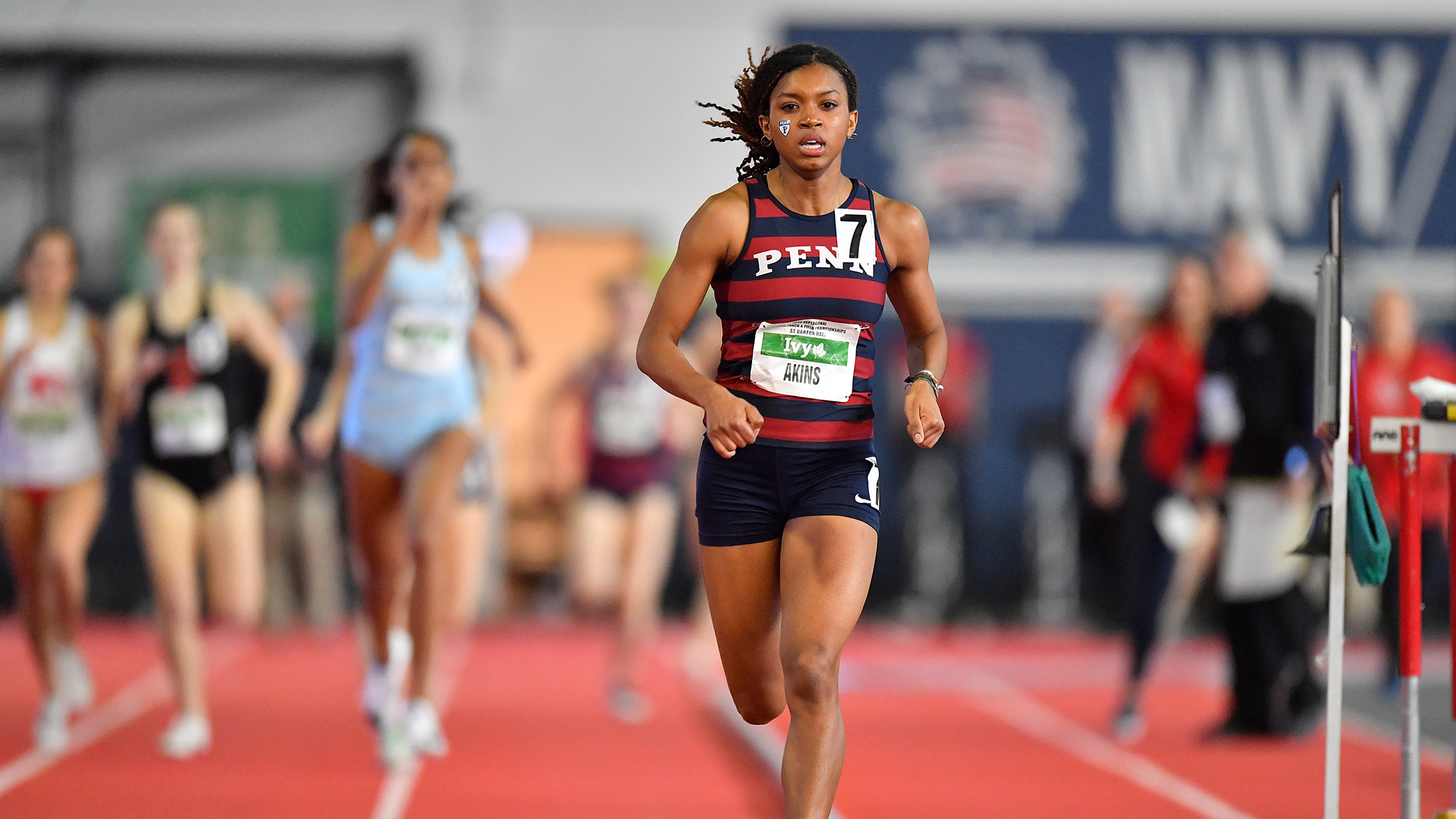 Nia Akins leads the pack during a race at an indoor track.