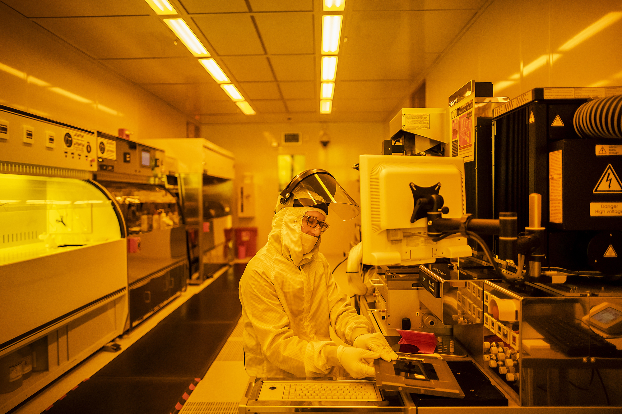 a person wearing protective gear works in a laboratory