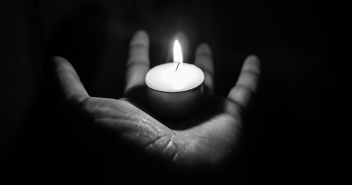 Open palm holding a small candle