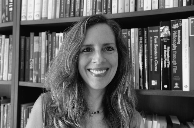 Professor in front of a bookshelf filled with books