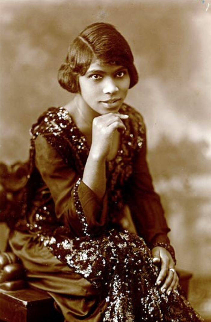 Portrait of Marian Anderson in 1920 in formal wear with her chin resting on her hand.