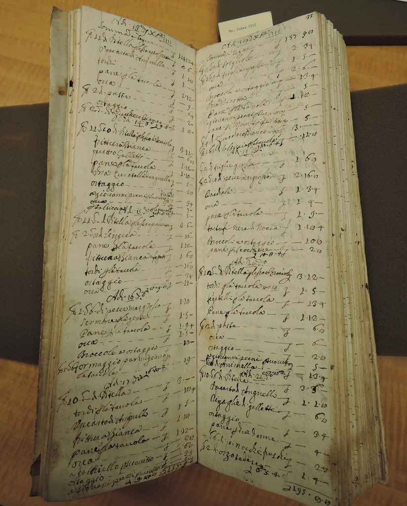 A narrow old book displays a list in Italian