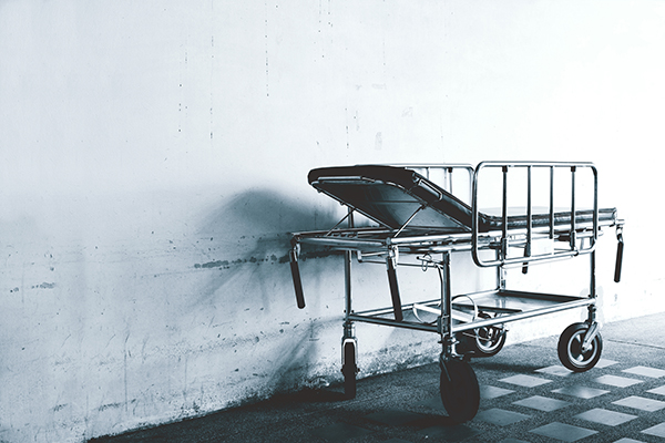 Single hospital bed in an abandoned hallway