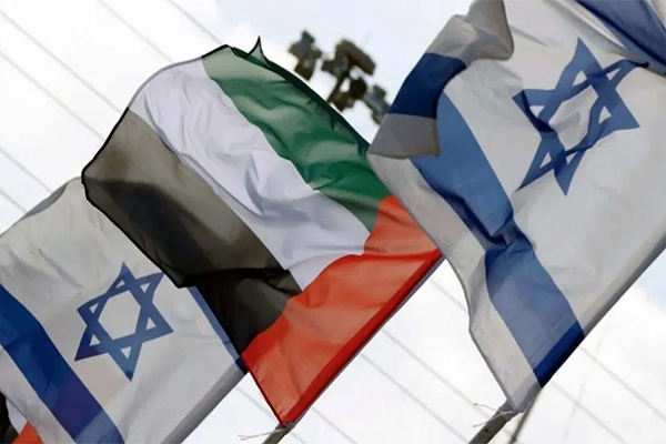 Two flags of Israel flying alongside one flag of the United Arab Emirates.