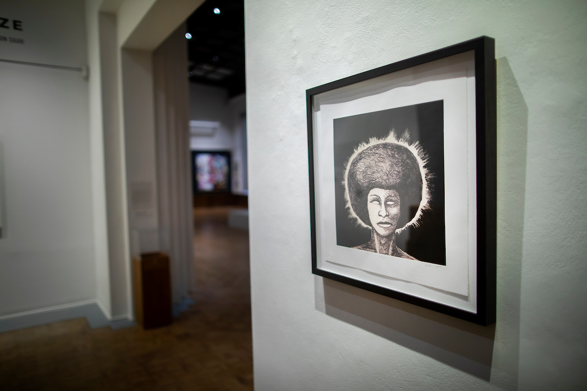 Artwork with a person with an afro with light shining all around it