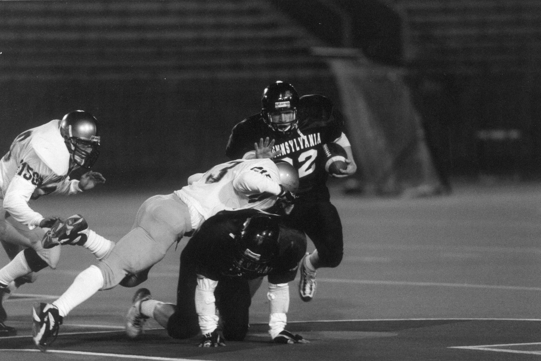 Tim Ortman stiffarms a defender while running the football during a game.